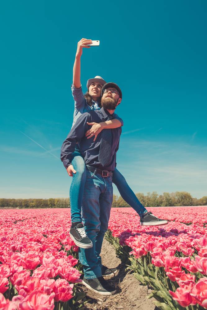 Couple standing tulip fields pink