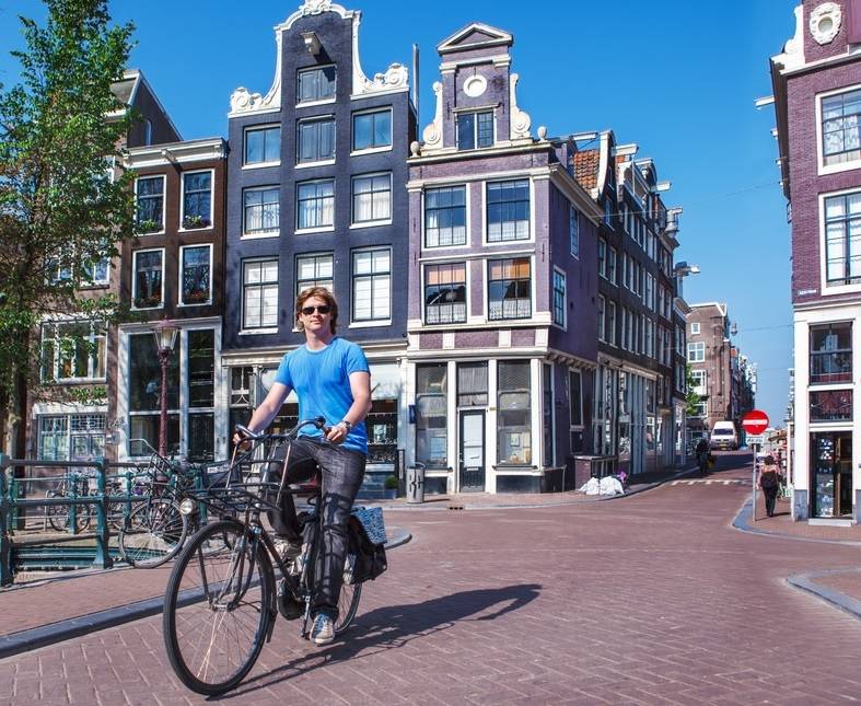 Man cycling Amsterdam bridge